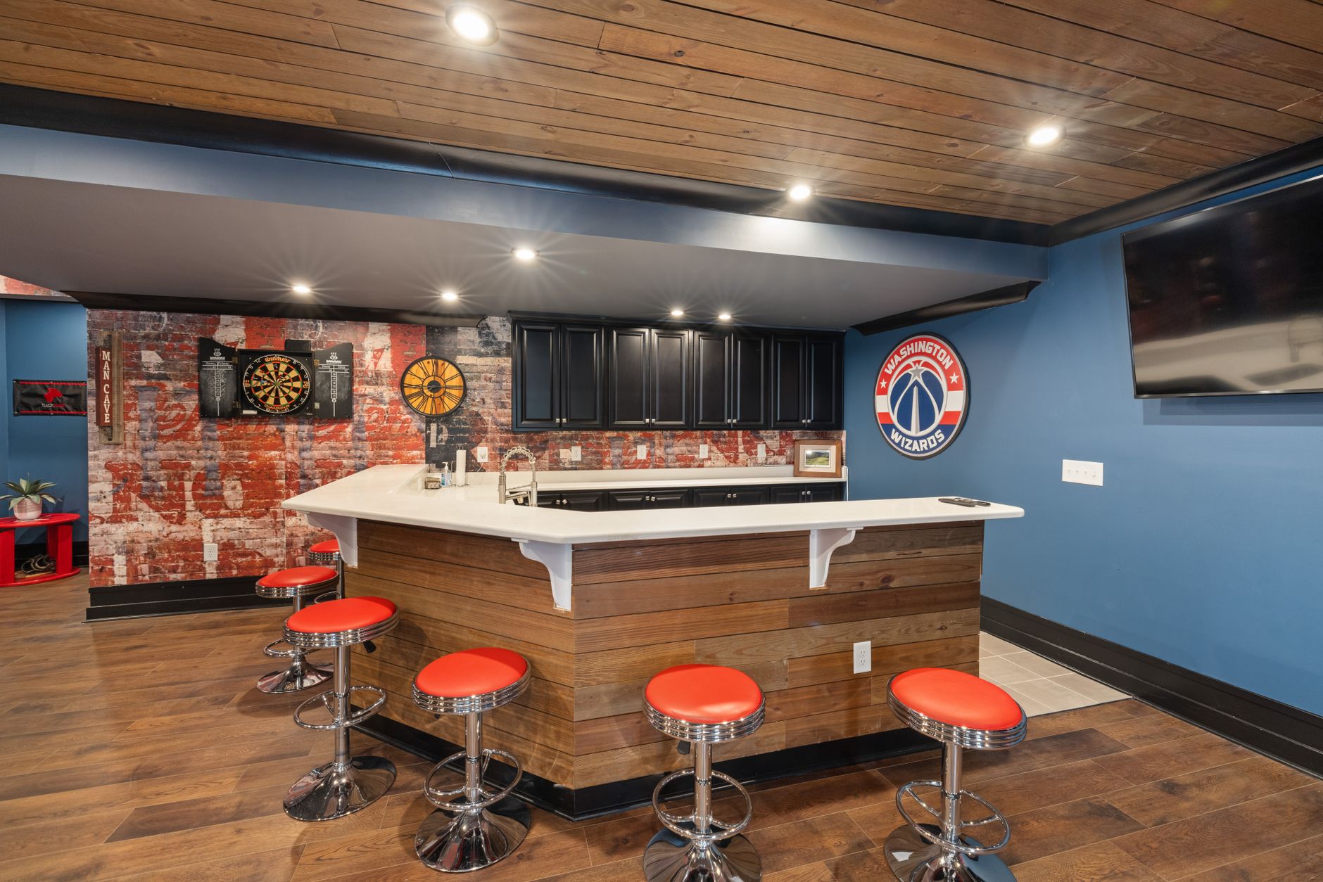 Stylish home bar with vibrant decor, featuring a Washington Wizards theme, dart board in Temecula, CA