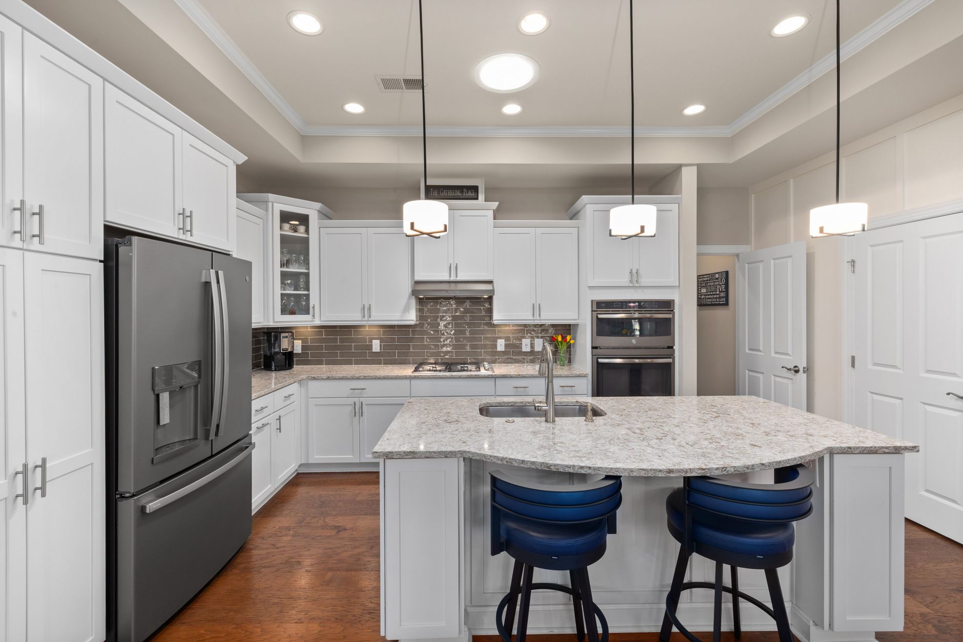 Elegant white kitchen interior featuring a marble island and stainless steel appliances in Temecula, CA